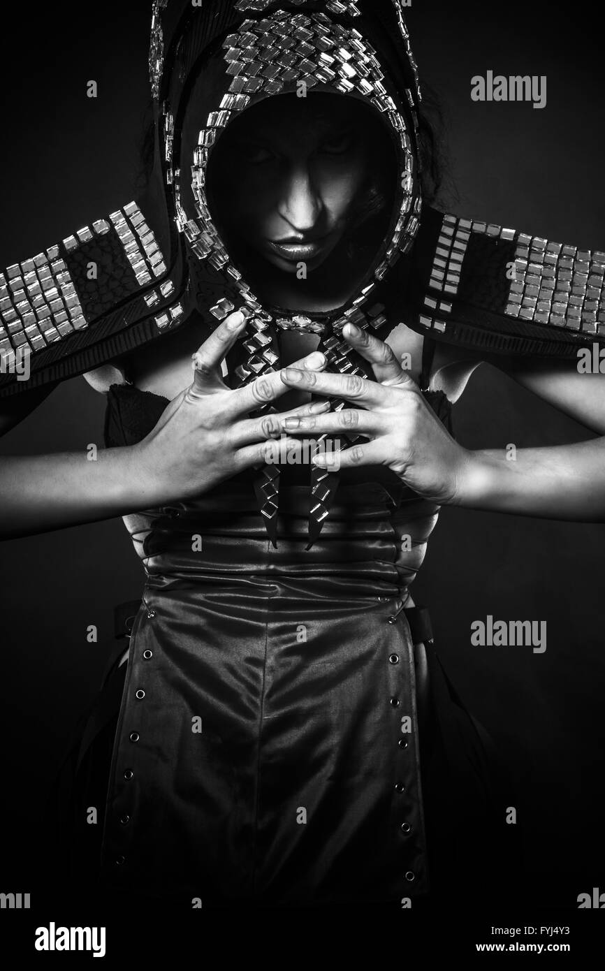 Strong, Beautiful brunette woman in armor formed by mirrors Stock Photo