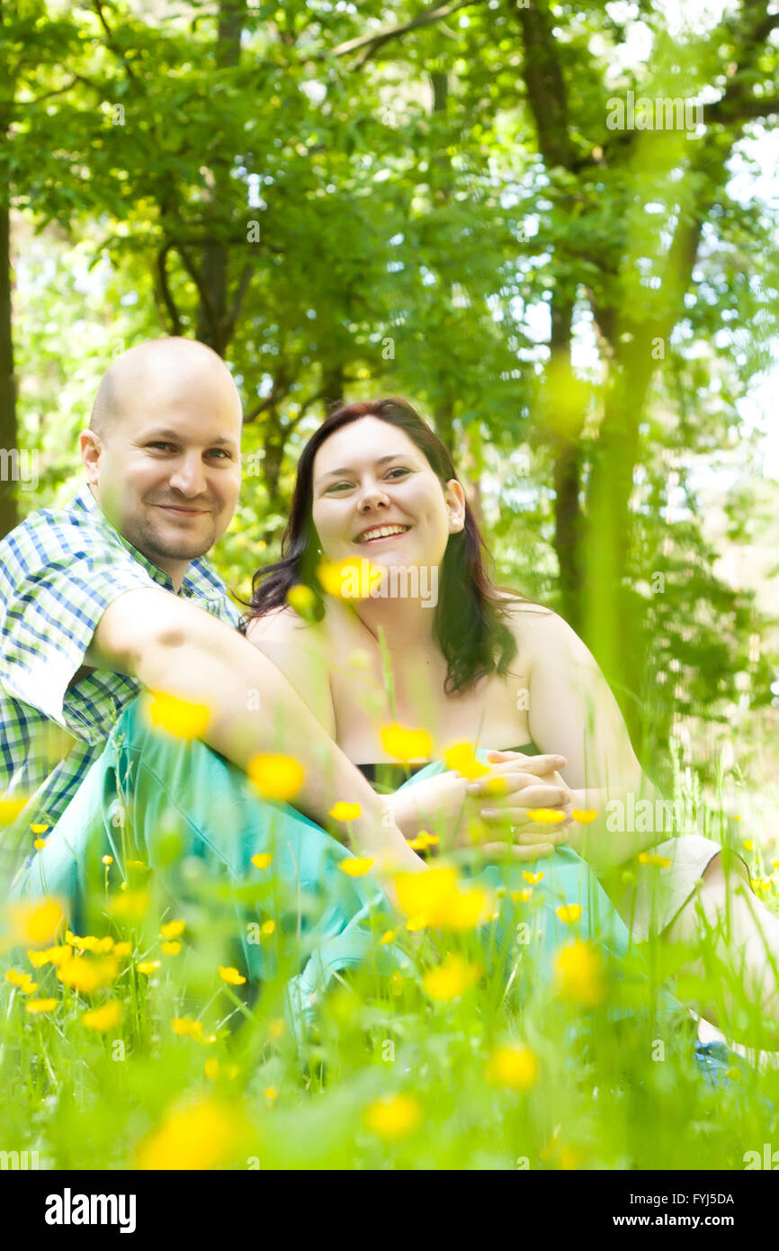 Happy young married couple between flowers Stock Photo - Alamy