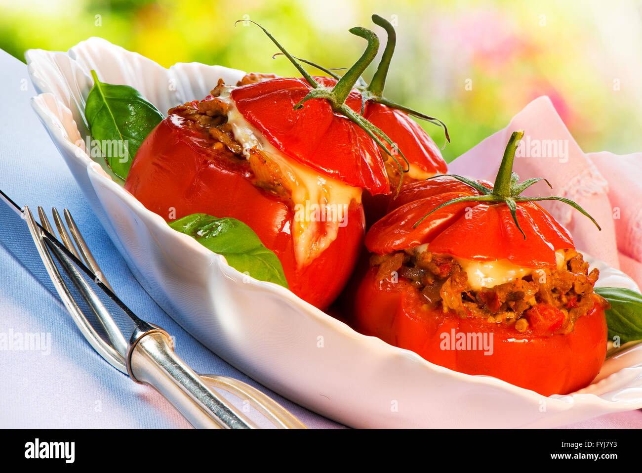 Three stuffed tomatoes on a white plate Stock Photo
