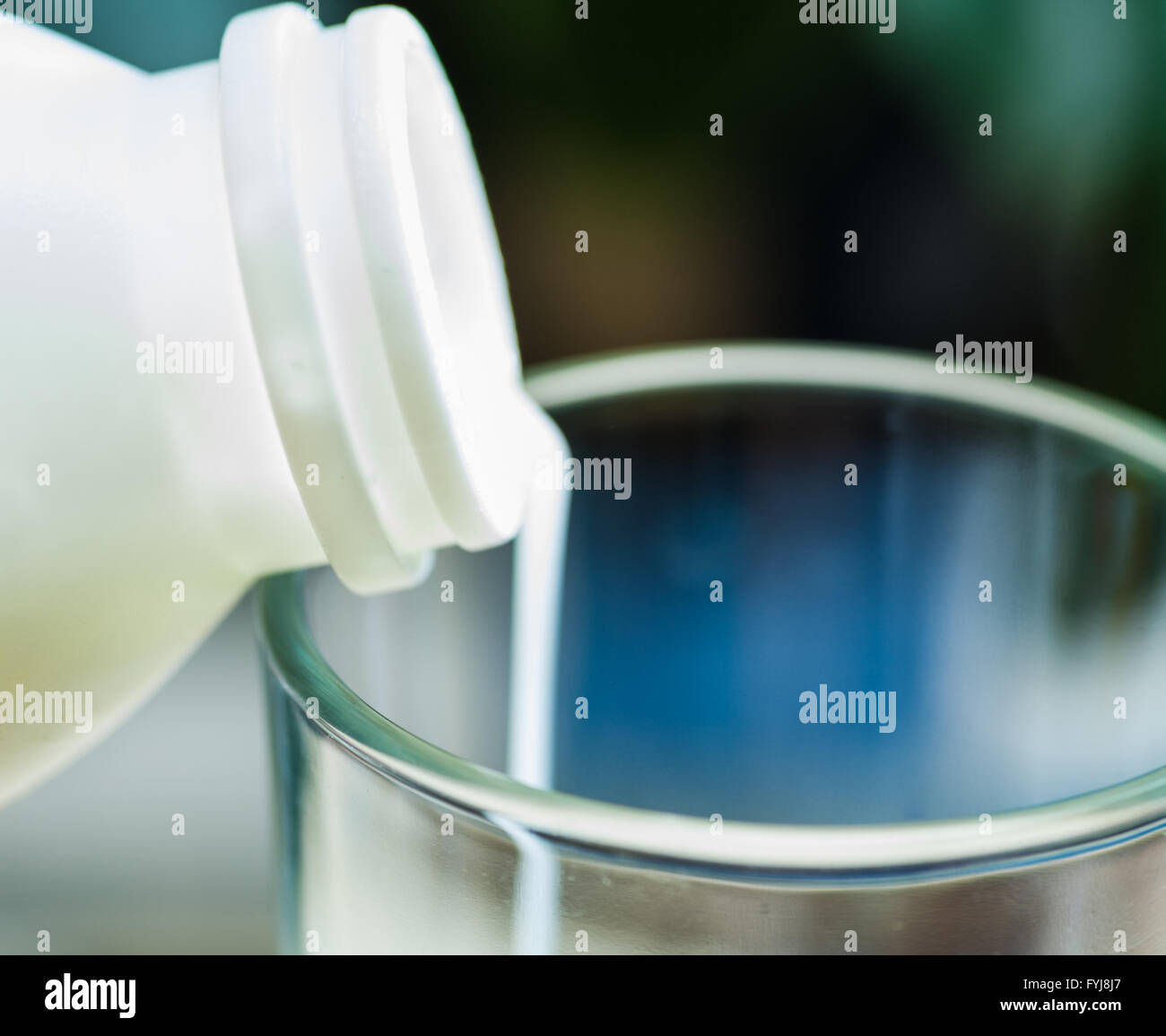 milk poured in glass cup over indoors background Stock Photo