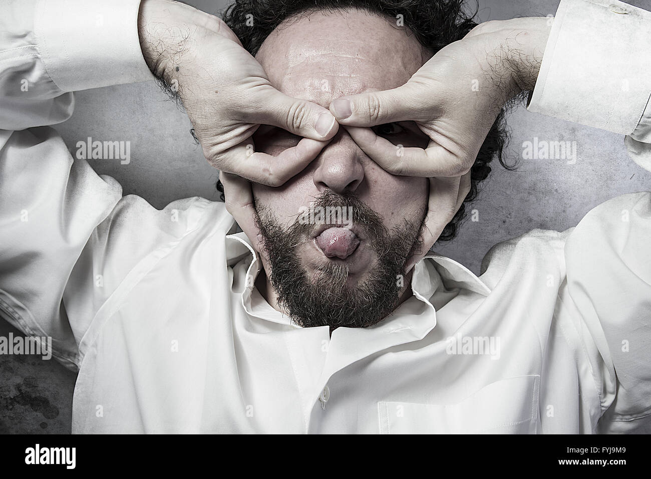 hands as a mask, man in white shirt with funny expressions Stock Photo