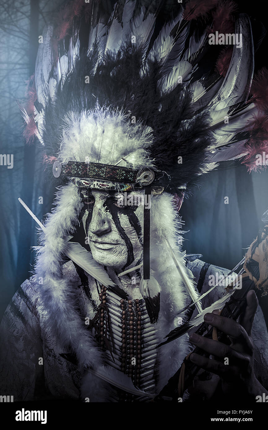 American Indian warrior, chief of the tribe. man with feather headdress and tomahawk Stock Photo