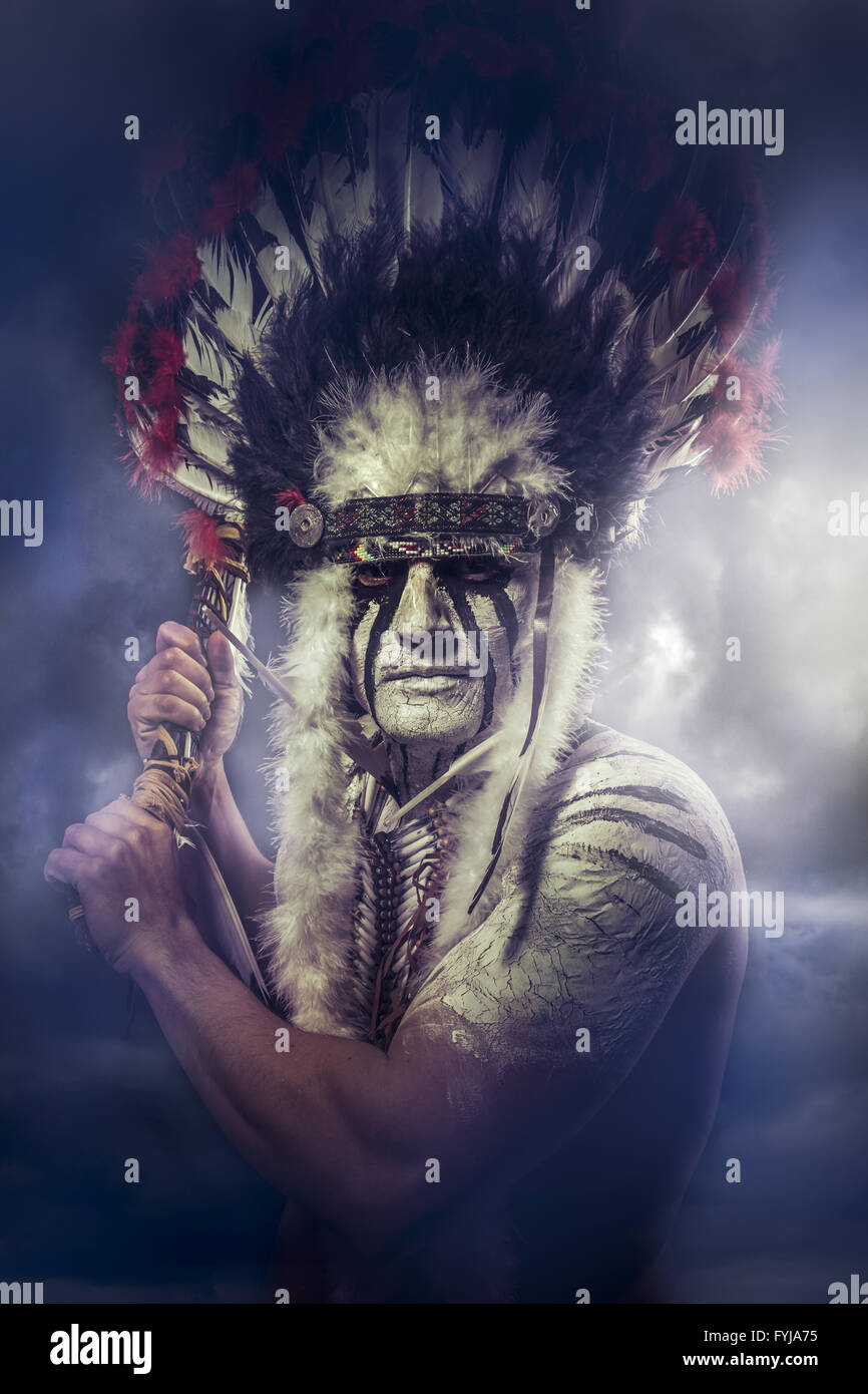 American Indian warrior, chief of the tribe. man with feather headdress and tomahawk, clouds Stock Photo