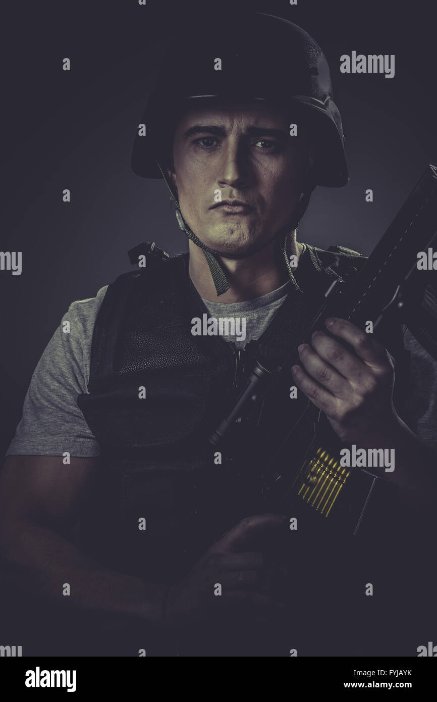 Airsoft, paintball sport player wearing protective helmet aiming