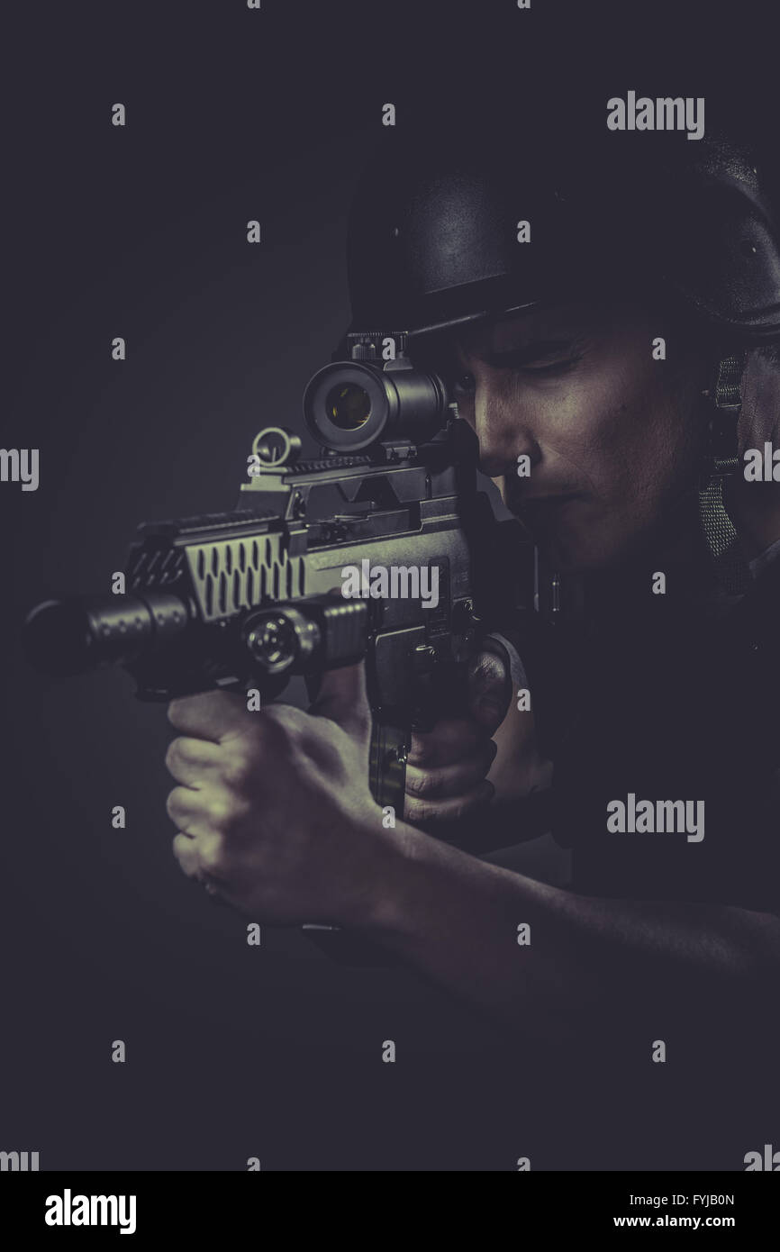 paintball sport player wearing protective helmet aiming pistol ,black