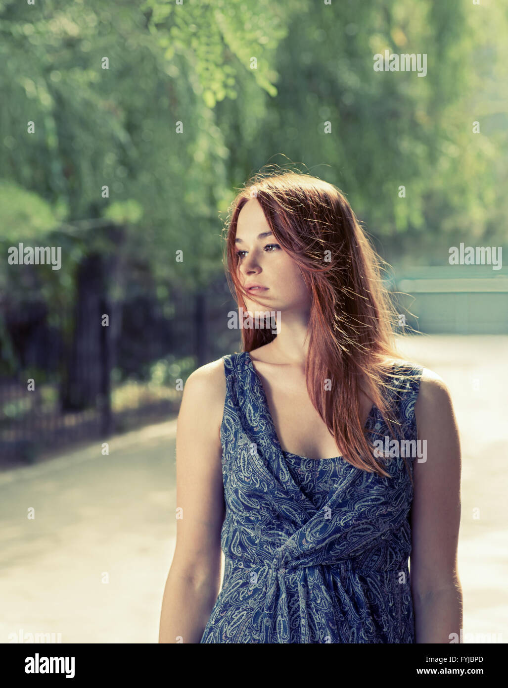 Toned image of a red haired women relaxing in a park Stock Photo