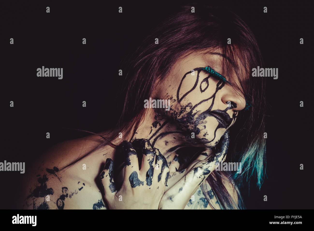 solitude concept, crying woman with tears and makeup dark light Stock Photo