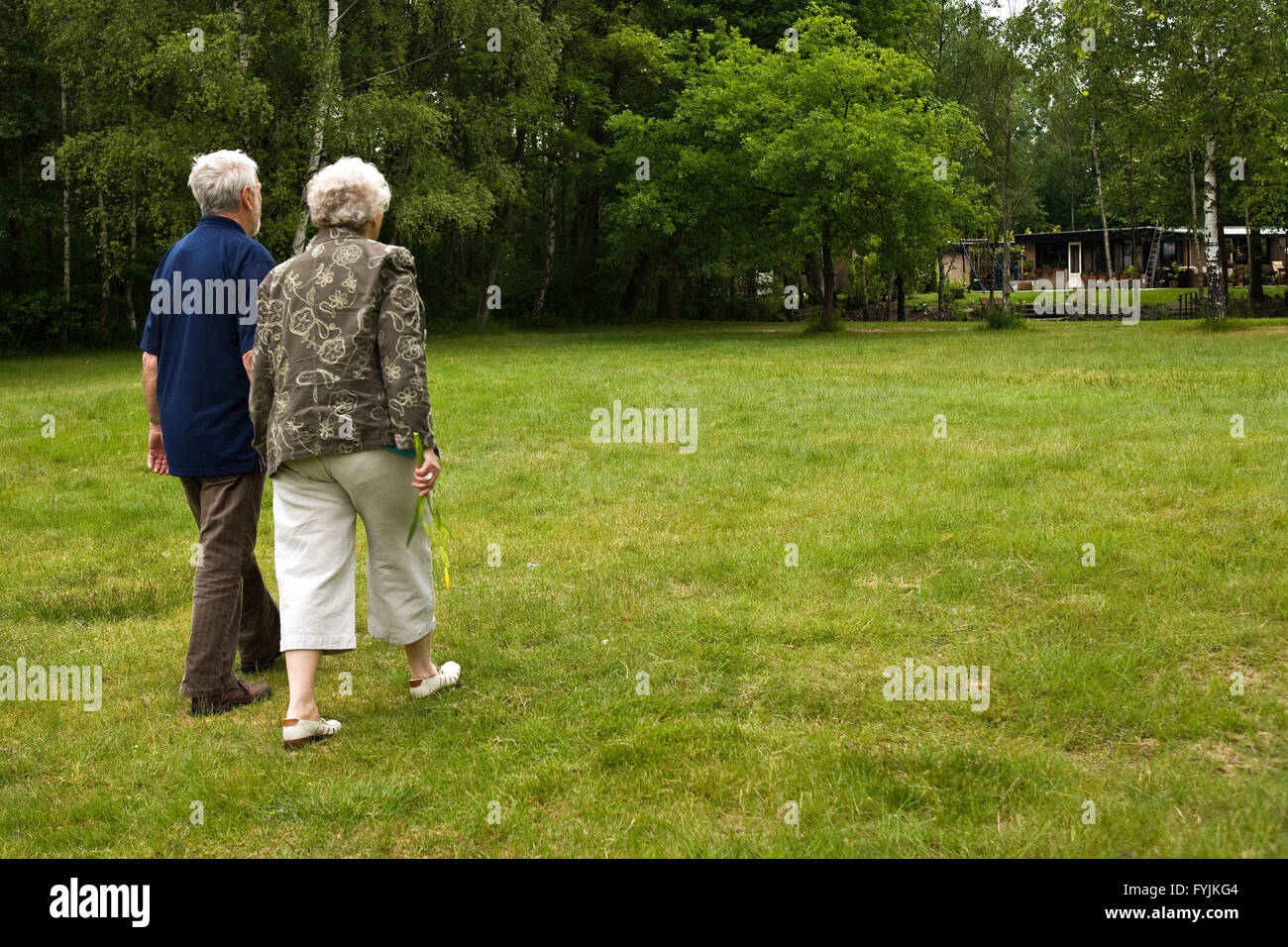 Older couple walking through a park Stock Photo