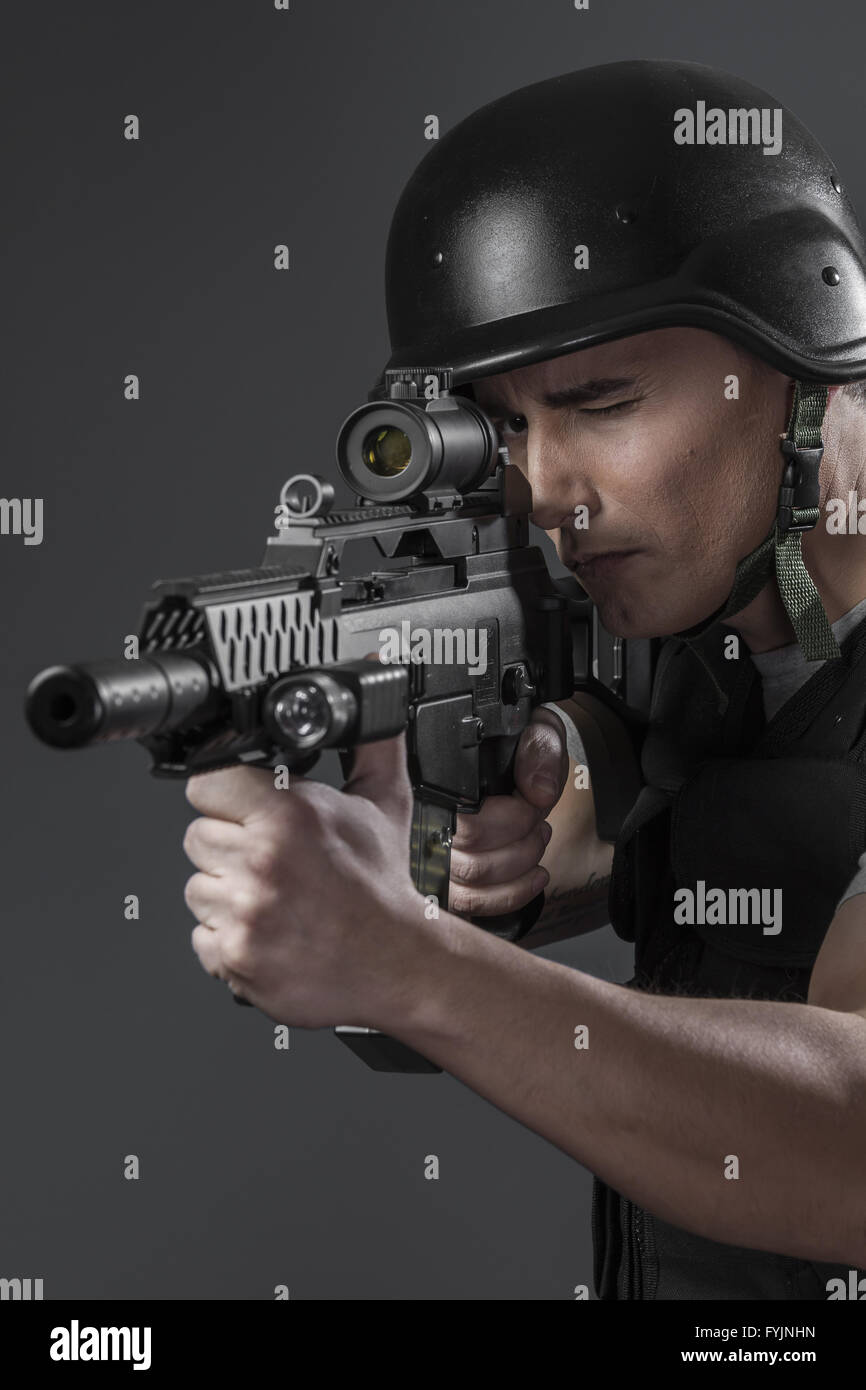 paintball sport player wearing protective helmet aiming pistol ,black