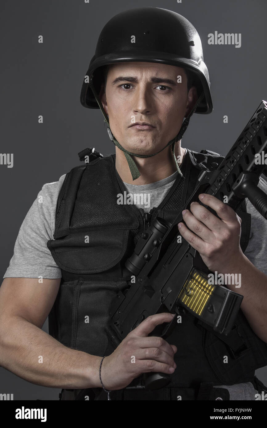 Soldier, paintball sport player wearing protective helmet aiming pistol