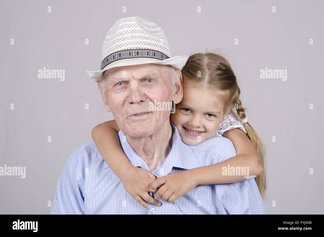 Portrait of an old man eighty years with granddaughter Stock Photo