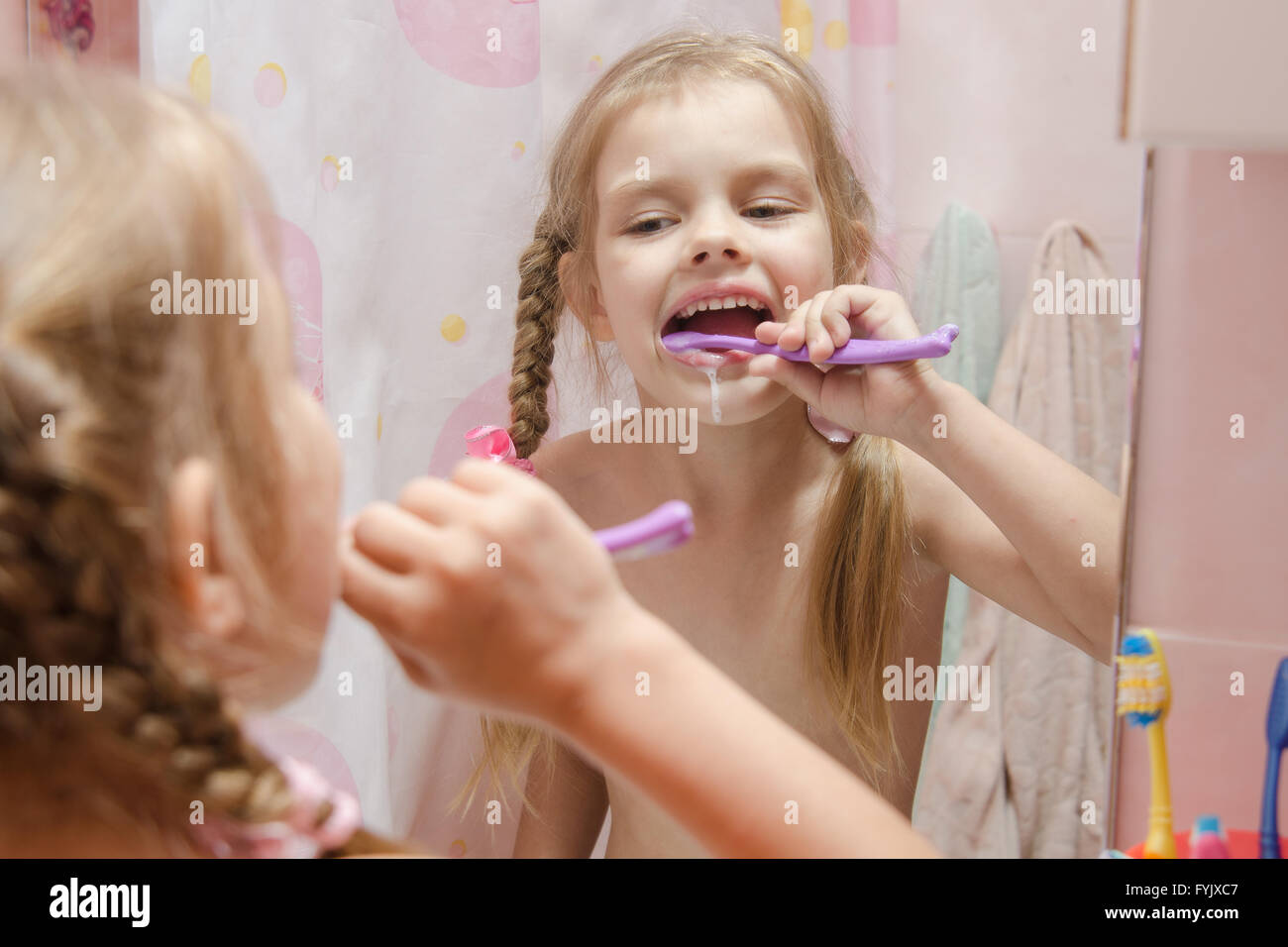 Five-year girl brushing her teeth in bathroom Stock Photo