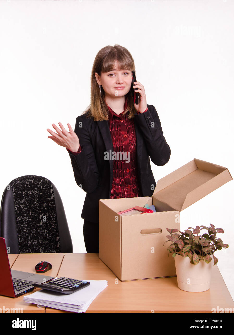 Girl in office collects personal belongings and calling on phone Stock Photo