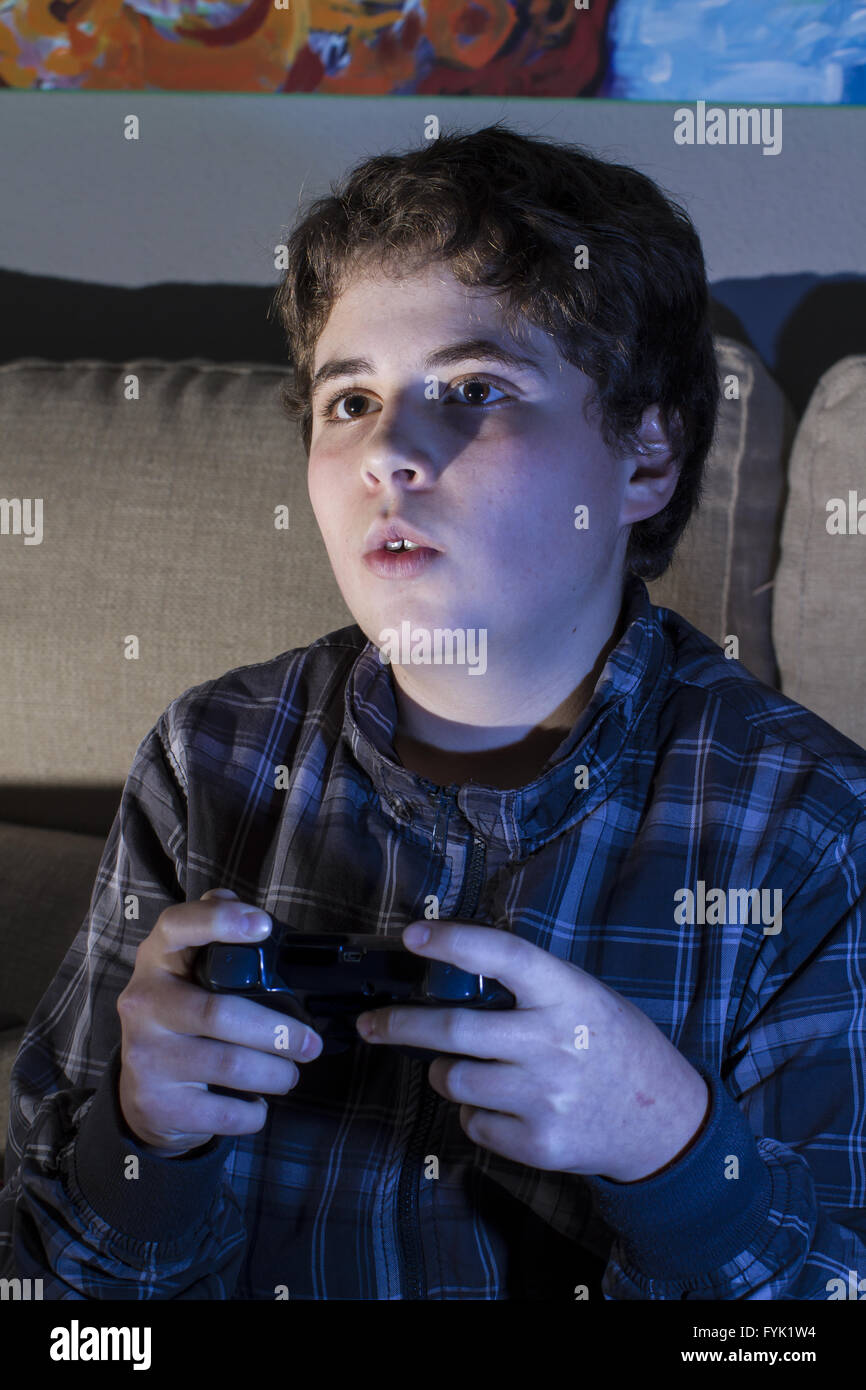 Entertainment. boy with joystick playing computer game at home Stock