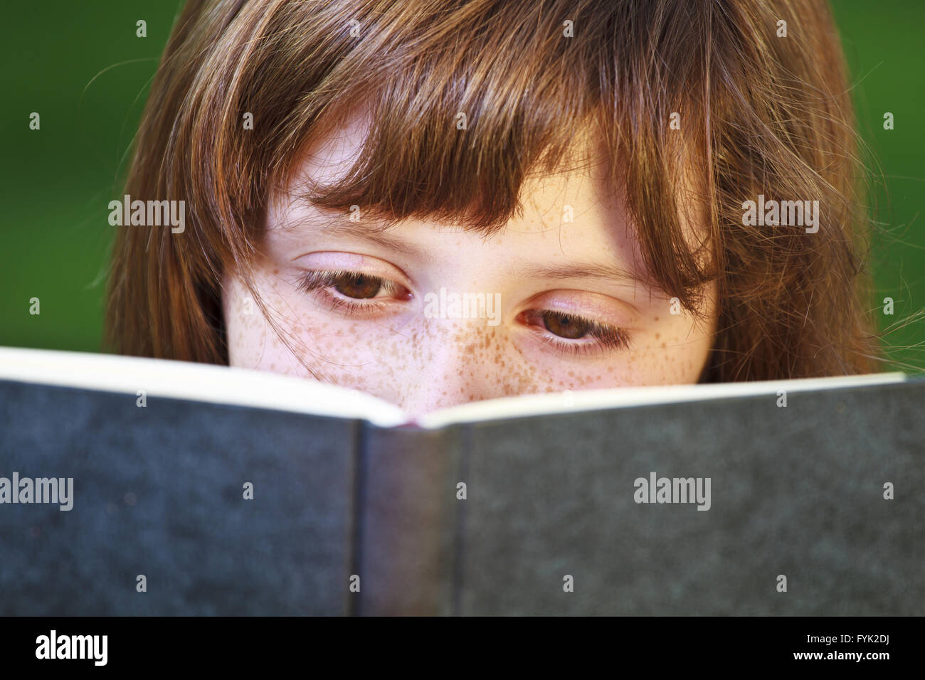 Young beautiful girl reading a book outdoor Stock Photo - Alamy