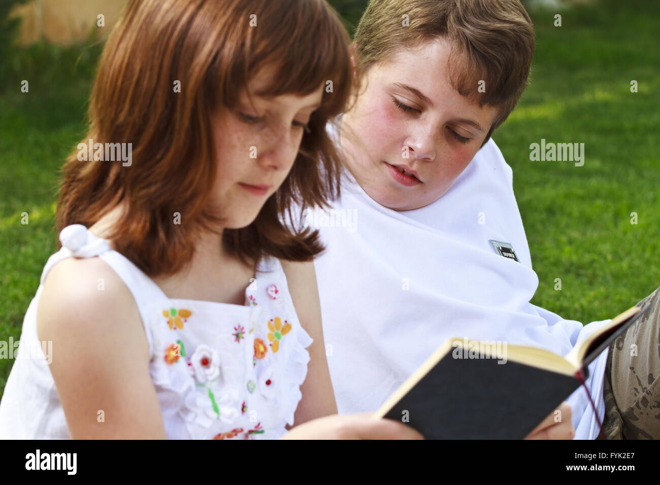 Teen.Portrait of cute kids reading books  in natural environment Stock Photo
