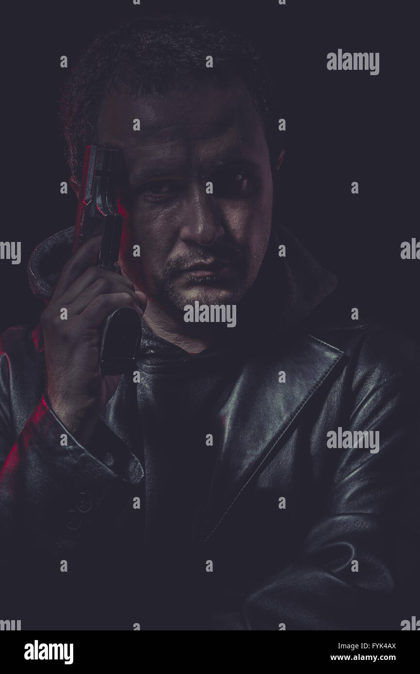 Suicide, Assassin, man with black coat and gun Stock Photo