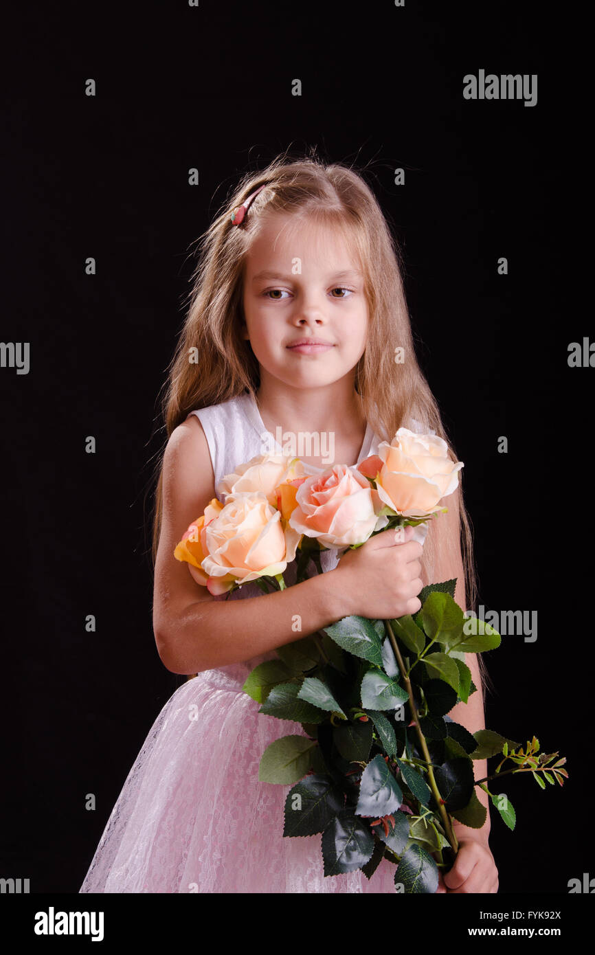 Sad five year old girl with a bouquet of flowers Stock Photo Alamy