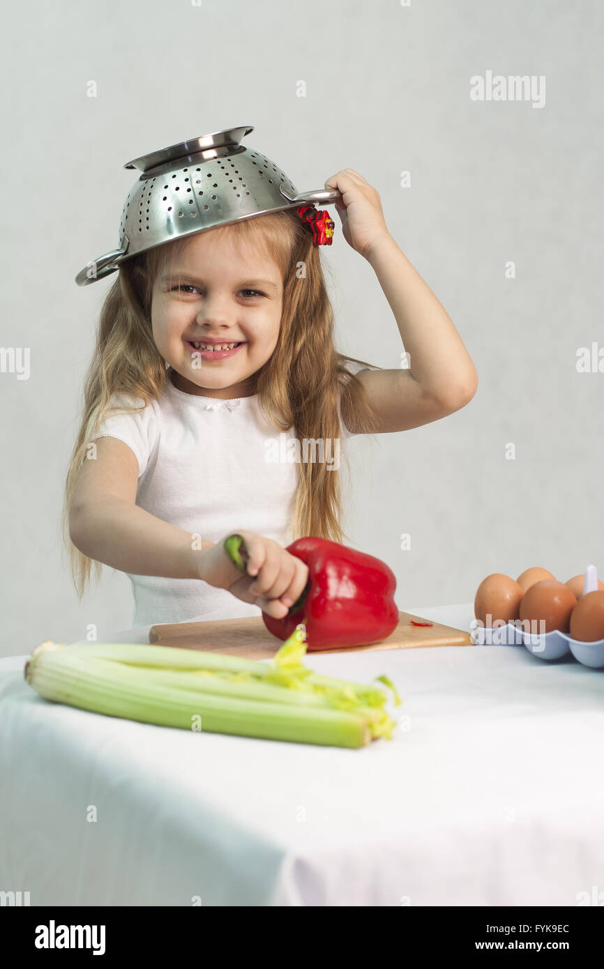 Girl playing in cook put a colander on his head Stock Photo Alamy