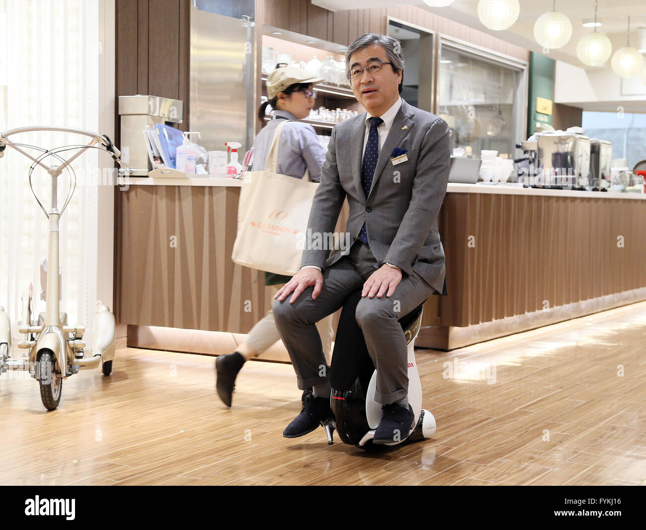 Tokyo, Japan. 27th Apr, 2016. Yoji Naka, the manager of Japan's Mitsukoshi department main store demonstrates a personal mobility device 'Uni-Cub beta', developed by Japanese auto giant Honda Motor at the Hajimarino Cafe of the main store of Mitsukoshi in Tokyo on Wednesday, April 27, 2016. The Mitsukoshi and Honda started customer services using the saddle style mobility, such as test drive inside the department store. Credit:  Yoshio Tsunoda/AFLO/Alamy Live News Stock Photo