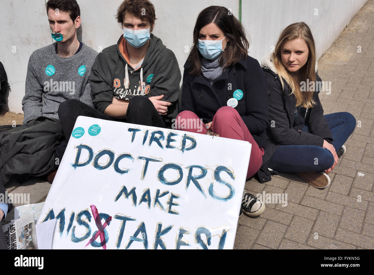 Bristol junior doctors sitting down in silent protest in front of the Bristol Royal Infirmary against the imposition of new contract terms set by Jeremy Hunt. Over 250  junior doctors demonstrating against the terms which they think will put patients at risk due to possible long hours on shift duty. “Credit: CHARLES STIRLING/Alamy Live News” Stock Photo
