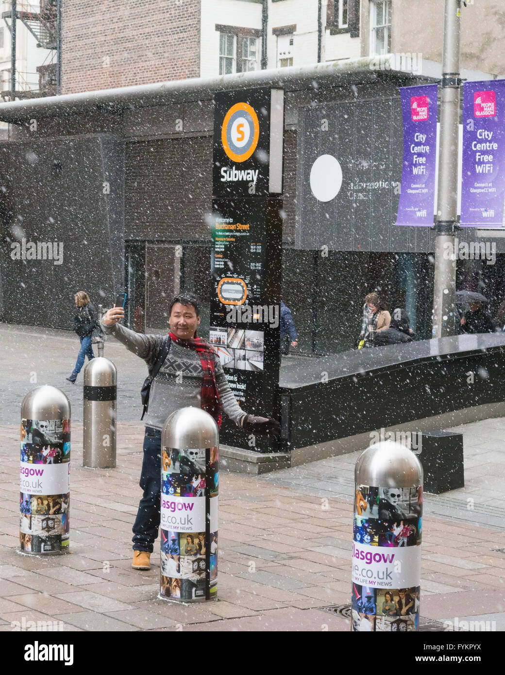 Glasgow, Scotland, UK. 27th Apr, 2016. UK weather - taking selfies in flurries of snow and hail in Glasgow on an otherwise bright sunny day in Glasgow Credit:  Kay Roxby/Alamy Live News Stock Photo