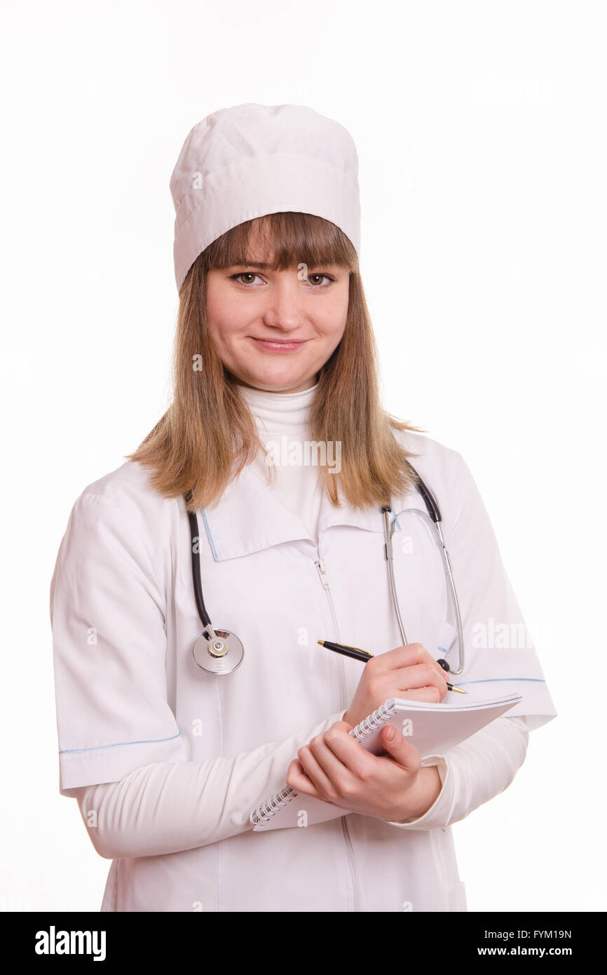 Medical officer in a white coat writes in a notebook information Stock Photo