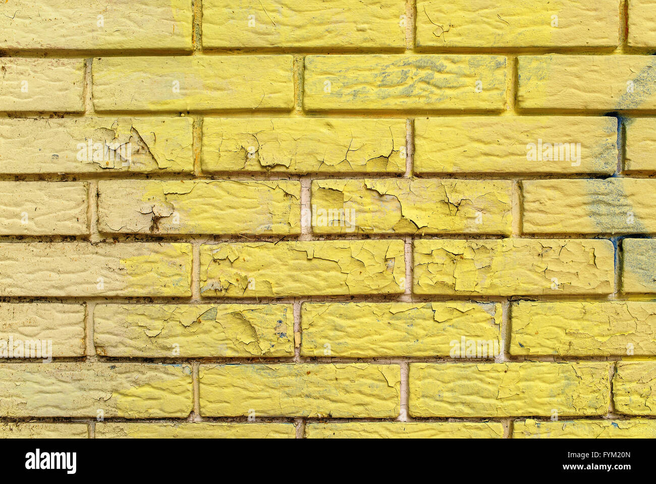 Yellow paint peeling of brick wall masonry surface, urban texture Stock Photo