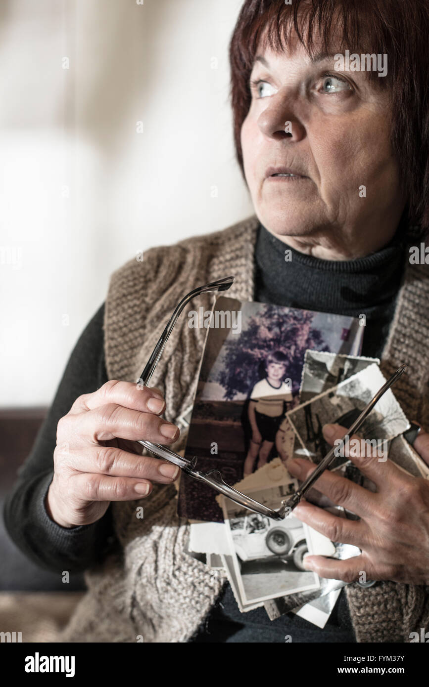 Senior woman watching old photos. Sadness Stock Photo