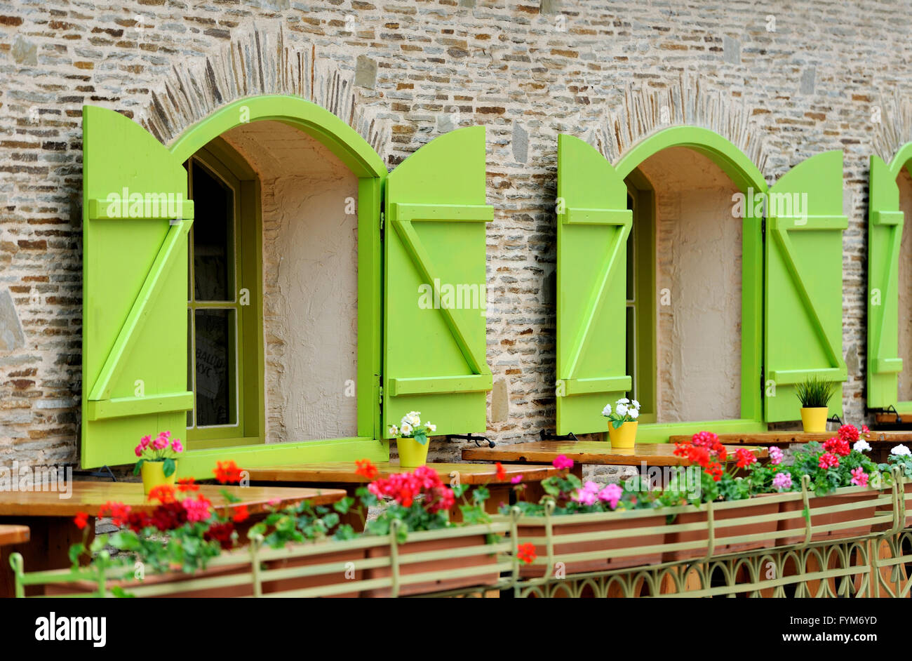 Wooden green house windows and beautiful street decorated with flowers Stock Photo