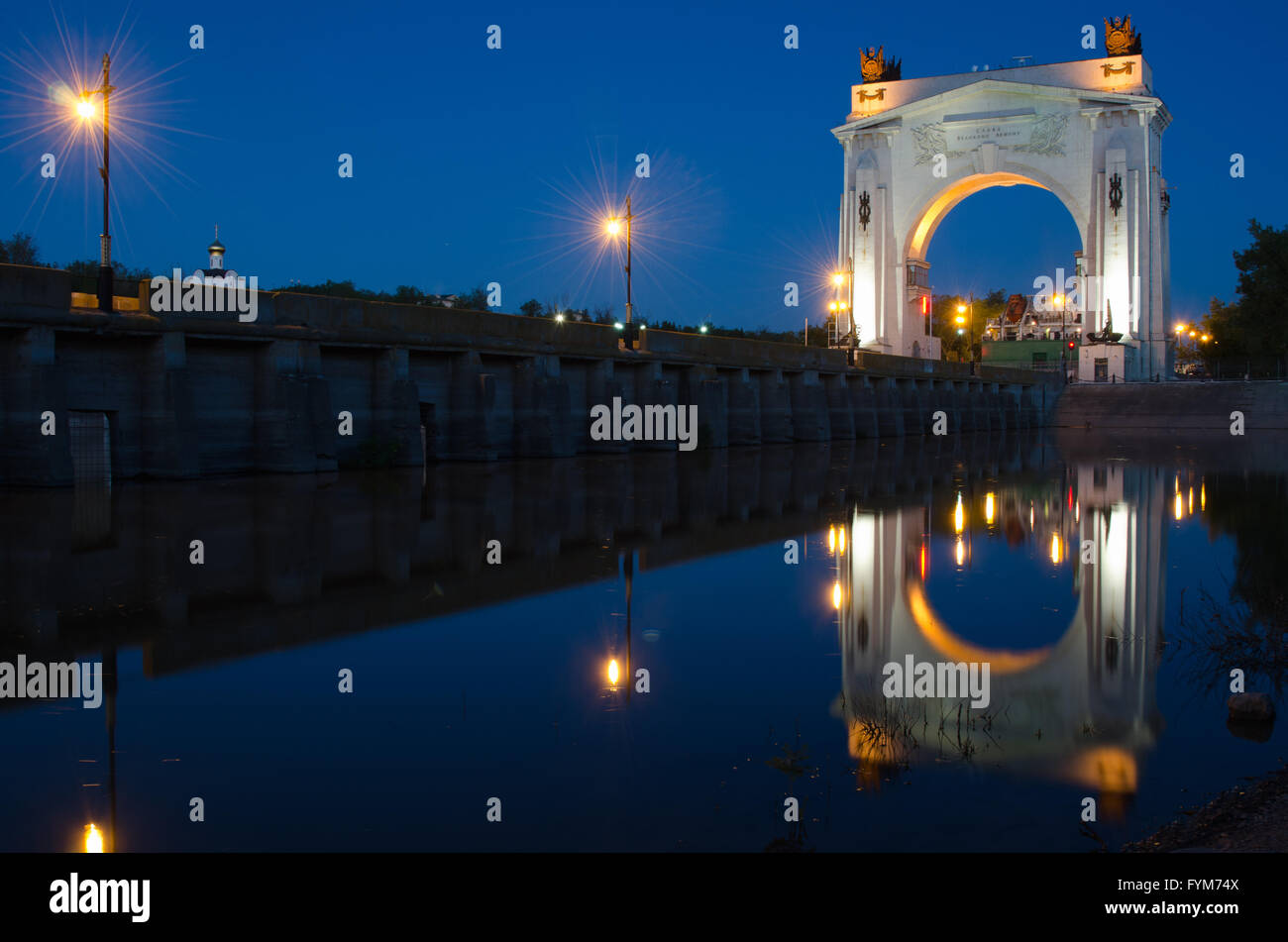 Evening view, with reflection on water arch, to first lock of Volga-Don Canal named after VI Lenina, Volgograd Stock Photo