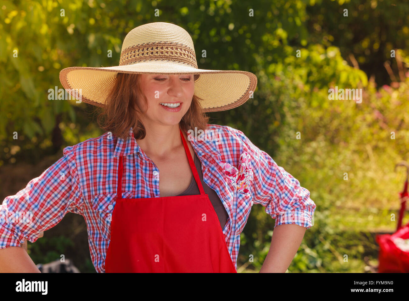 Portrait of mature smiling woman wearing big straw hat in garden Stock ...