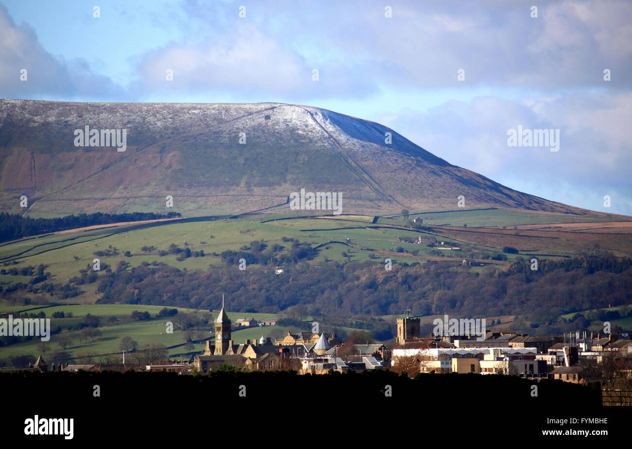 The 'Big End' of Pendle Hill with a dusting of snow looks down on the town of Colne, Lancashire. Stock Photo