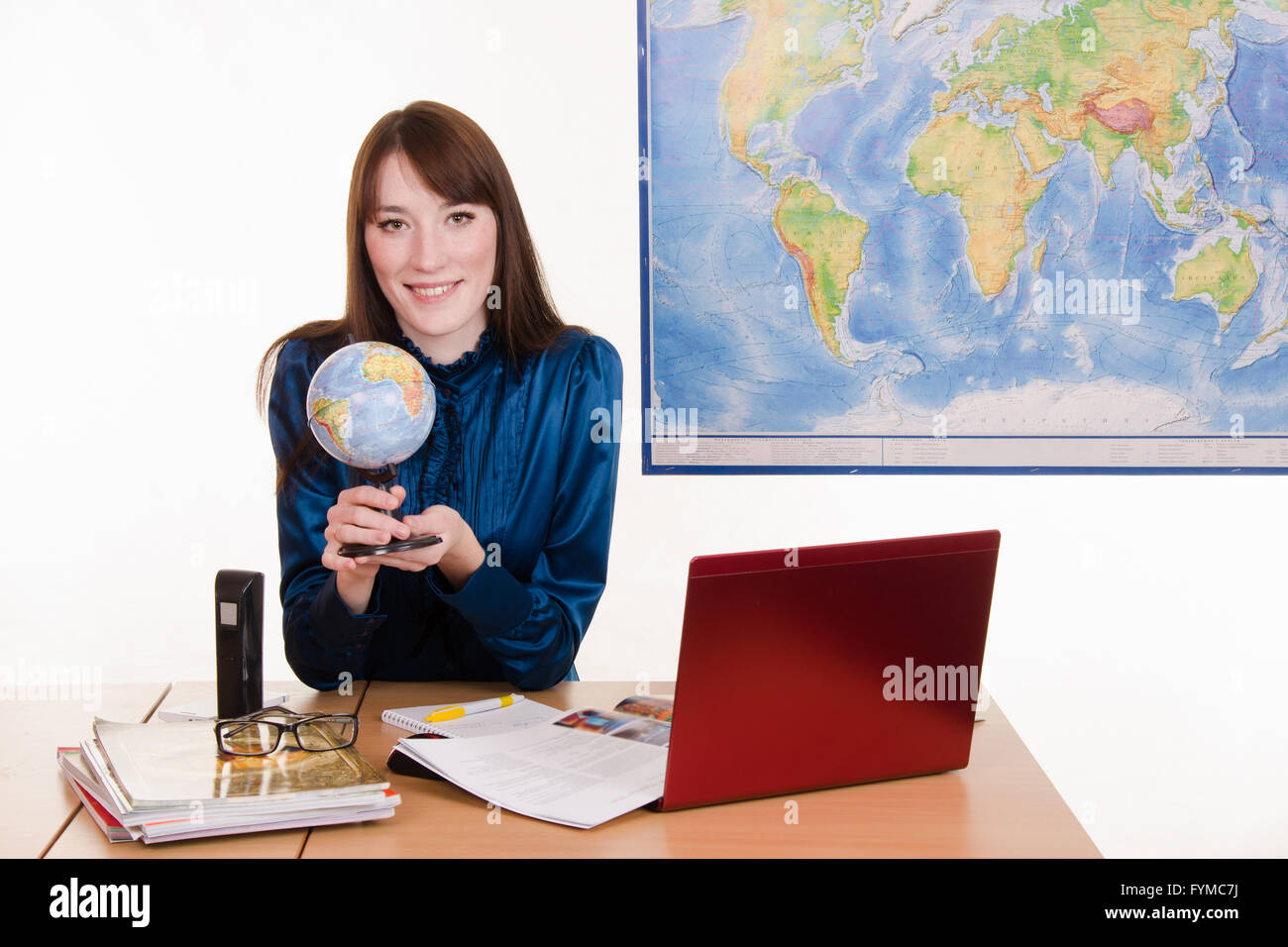 Cartographer sitting at the table with a globe in his hands Stock Photo