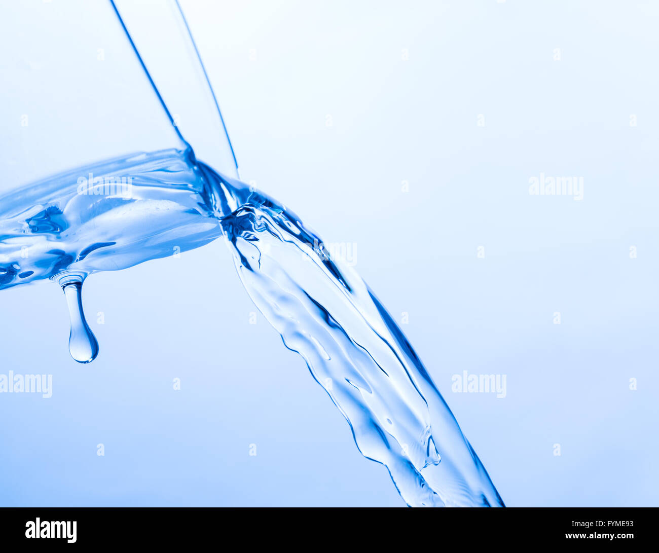 Cool Water Pouring from a Transparent Glass Cup Stock Photo