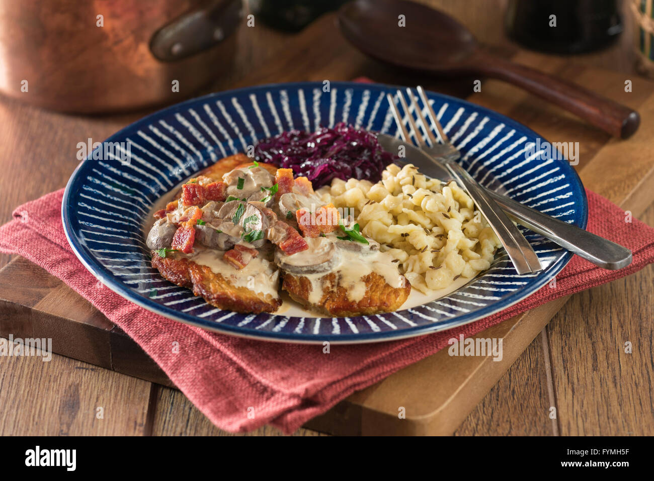 Jägerschnitzel with spätzle. Pork escalope with mushroom sauce and pasta. Germany Food Stock Photo