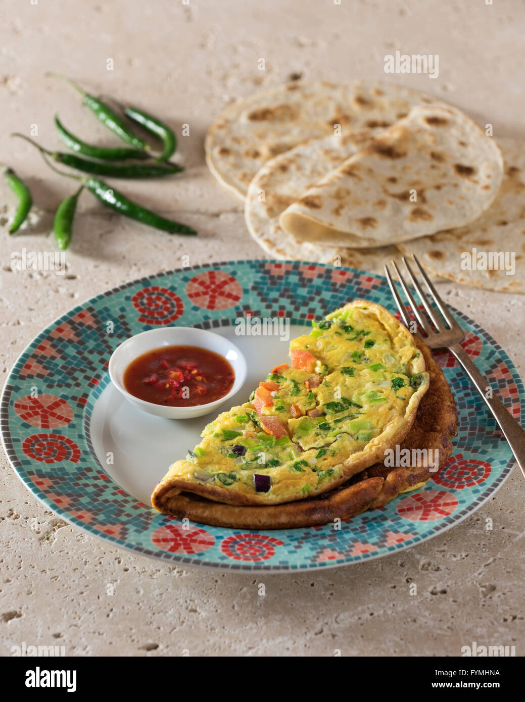 Masala omelette. Spicy Indian omelet with chilli ketchup and chapatis. India Food Stock Photo