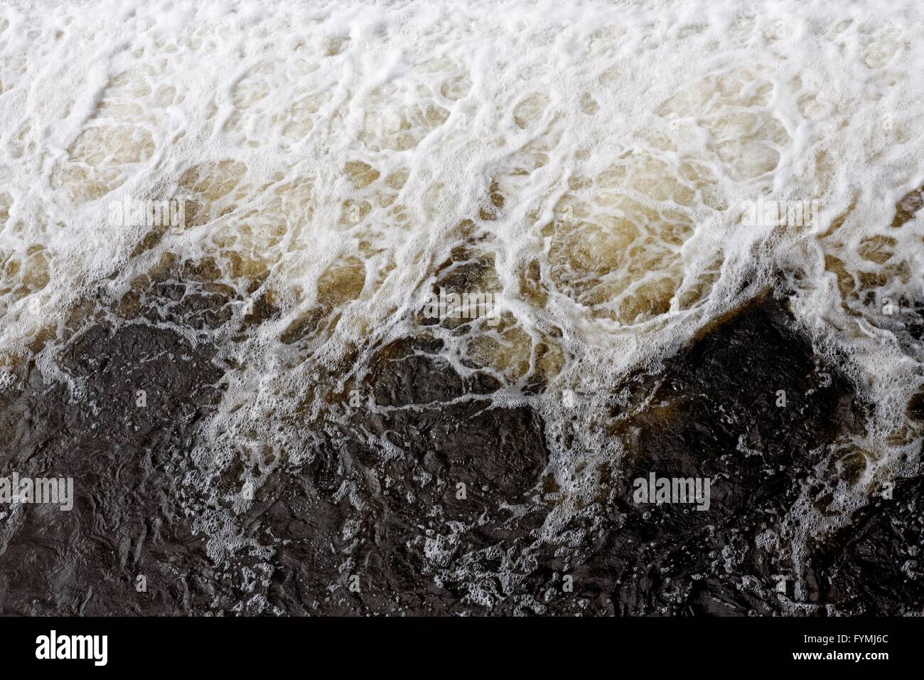 Swirling water at the bottom of a weir Stock Photo