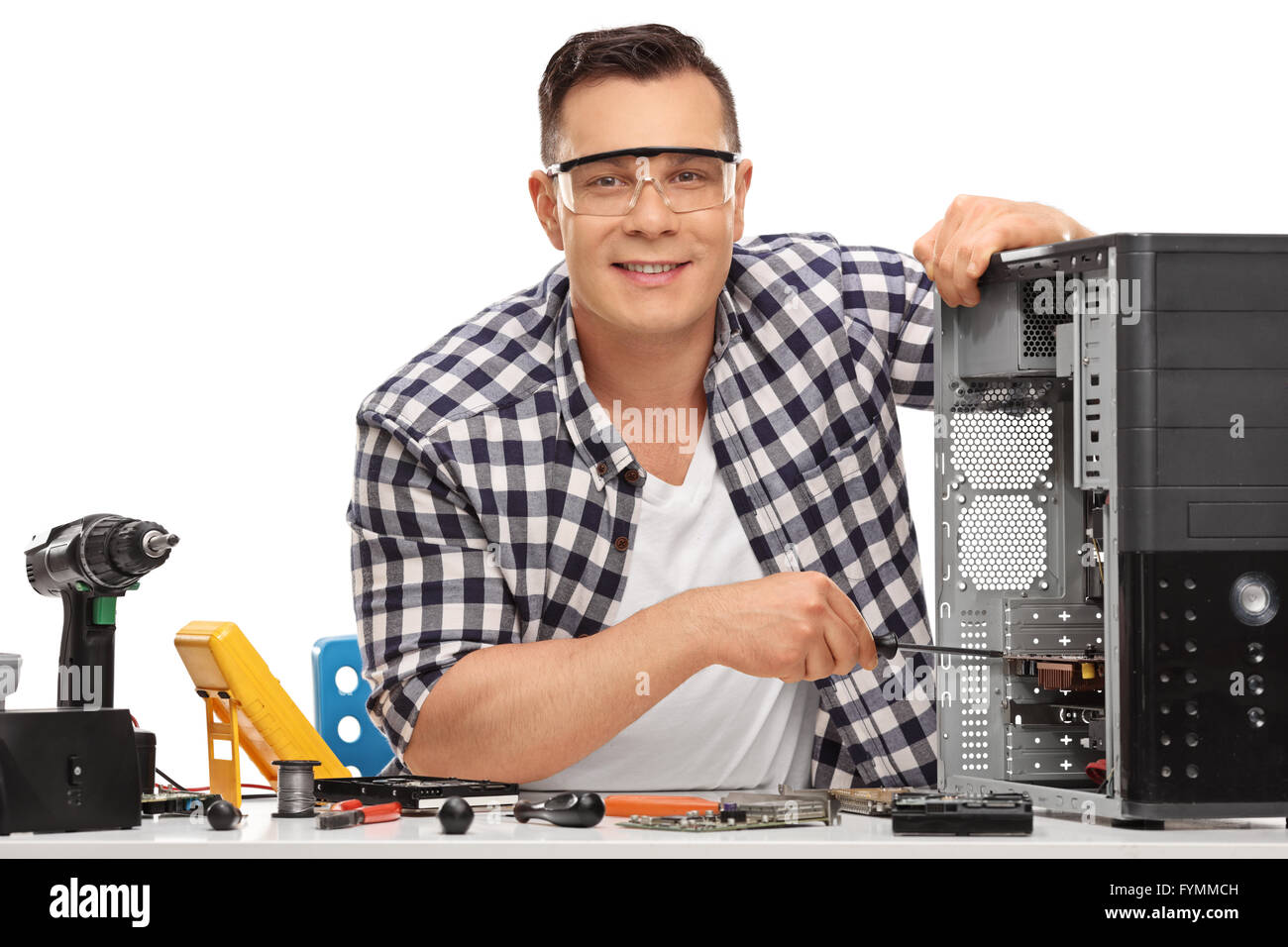 Young PC technician repairing a broken desktop computer and looking at the camera isolated on white background Stock Photo