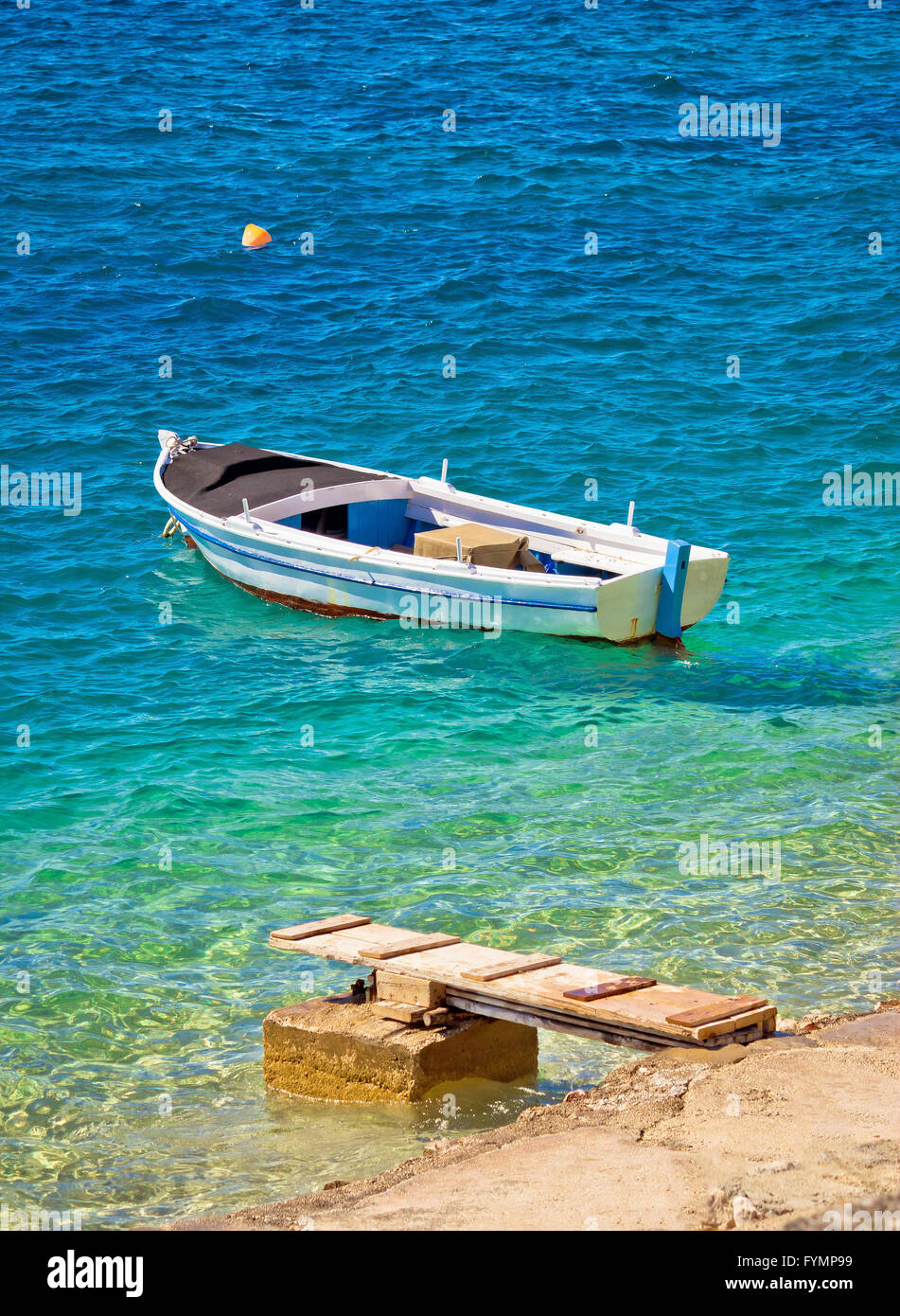 Old wooden fishermen boat on turquoise beach Stock Photo