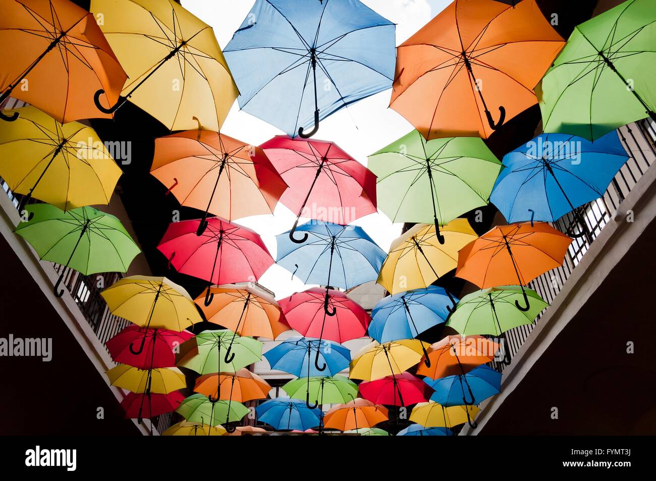 Street decoration with colorful open umbrellas hanging over the alley