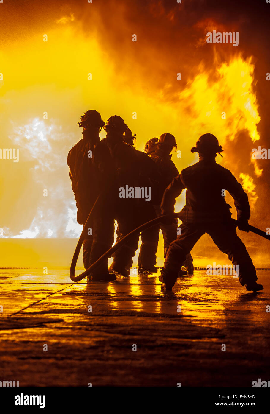 Firefighter bracing during firefighting Stock Photo