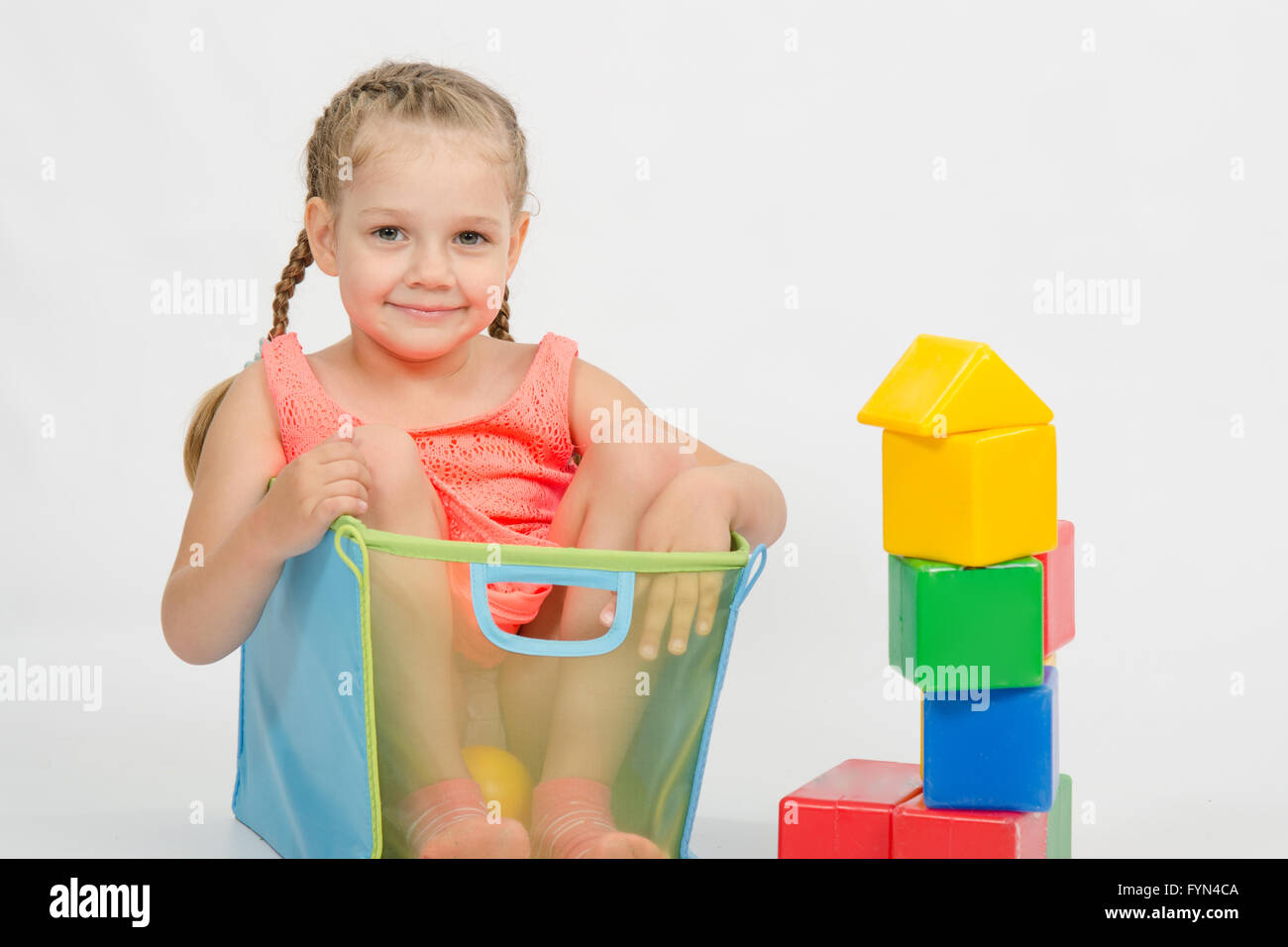 The girl climbed into a box for toys Stock Photo