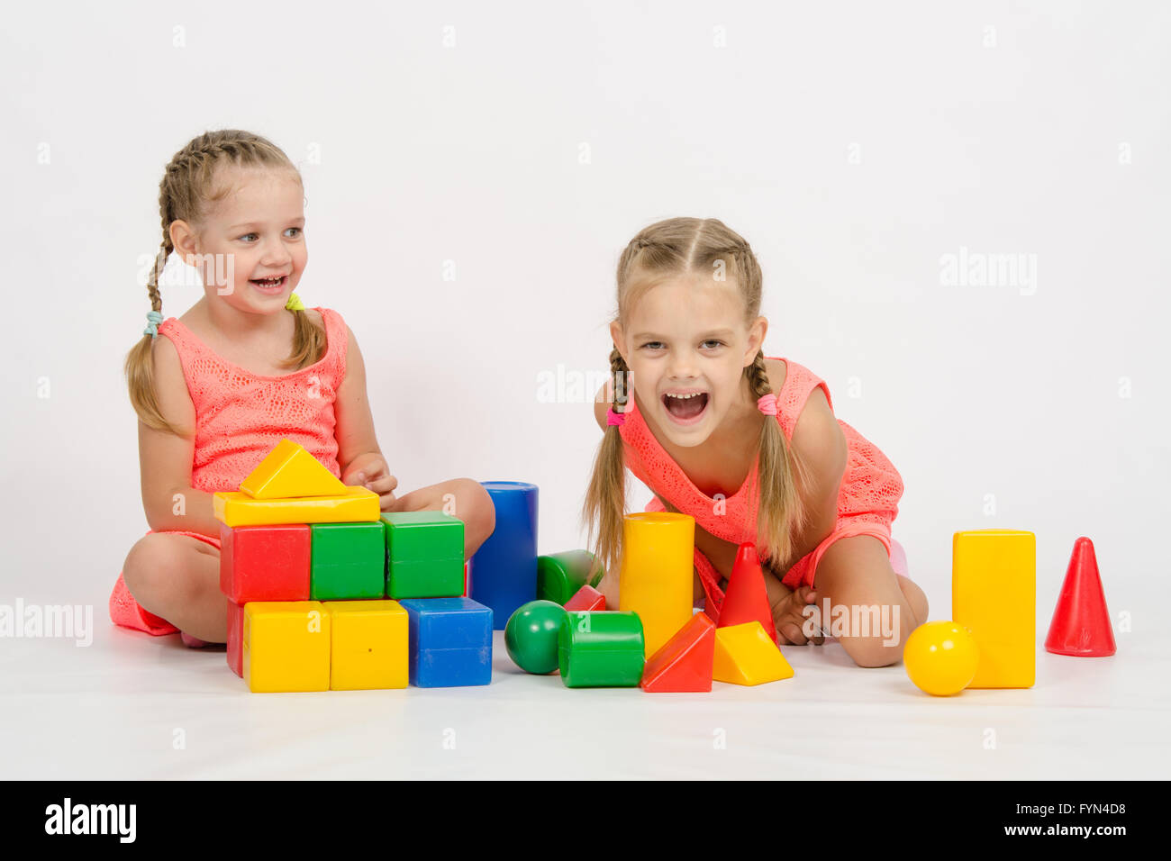 Two girls laughing uncontrollably playing dice Stock Photo