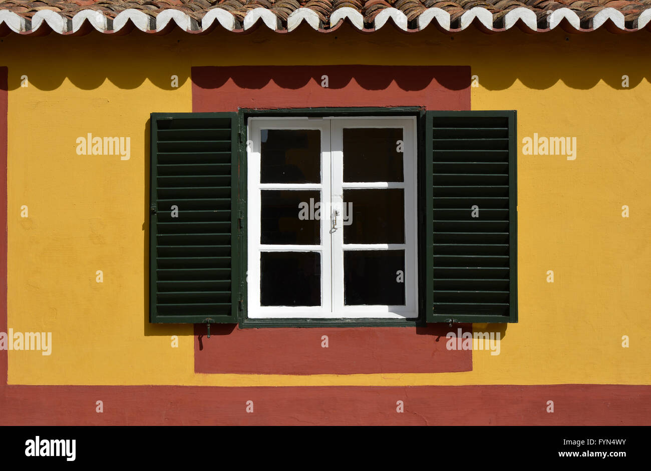 Window with shutters in yellow and red wall. Funchal, Madeira, Portugal