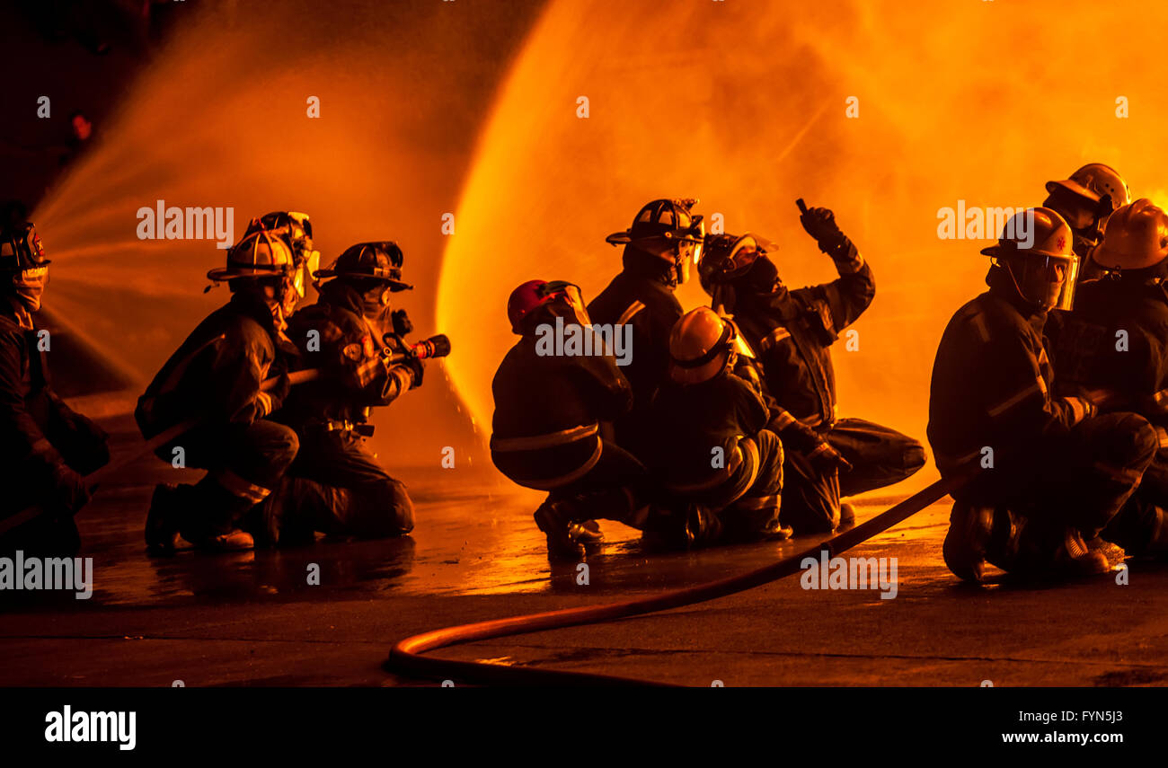 Firefighters discussing how to fight fire Stock Photo