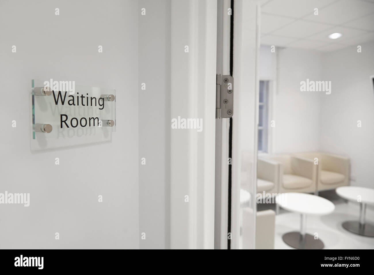 A waiting room sign outside an empty room. Stock Photo