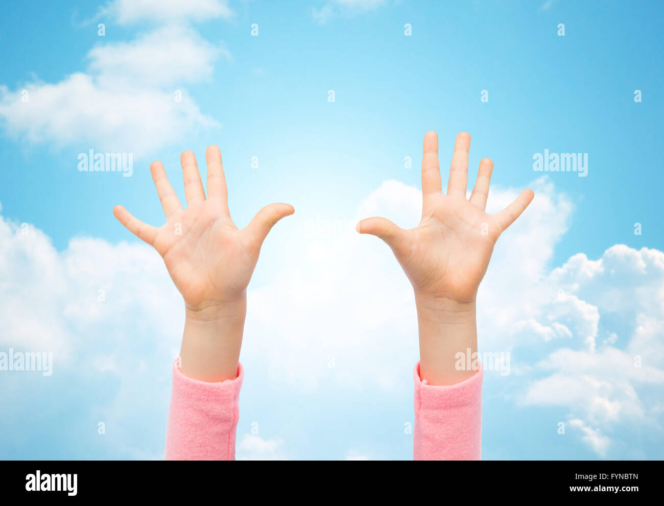 close up of little child hands raised upwards Stock Photo