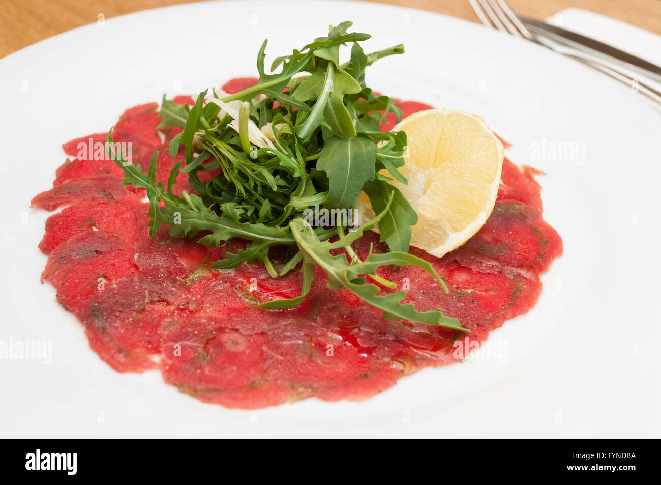 Beef Carpaccio with Parmesan Cheese, Lemon and Wild Rocket - Shallow Depth of Field Stock Photo