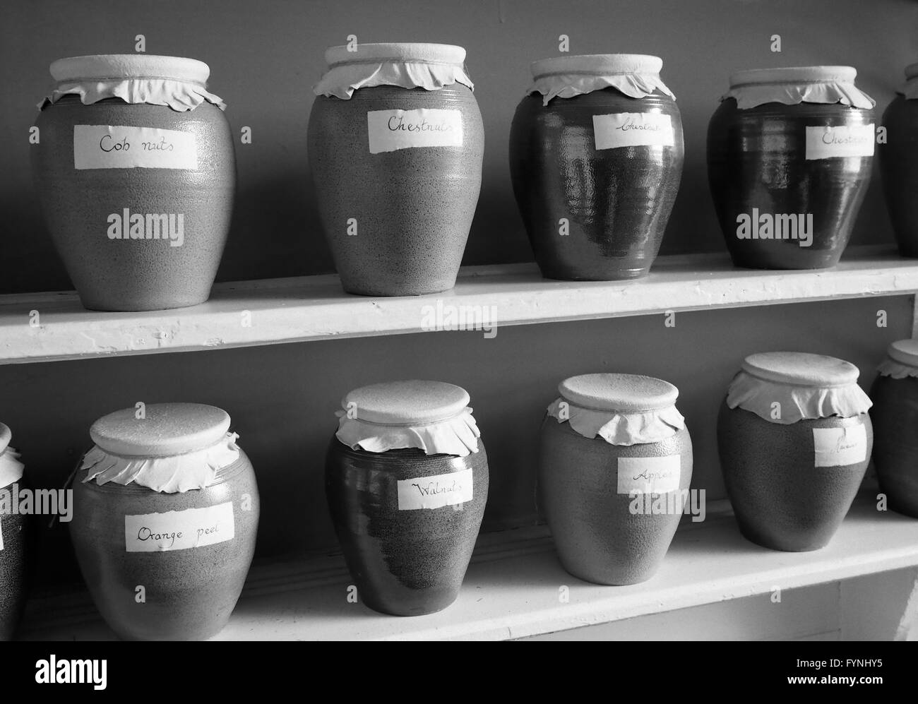 Mono images of food jars with cloth lids in an old kitchen in an English country kitchen Stock Photo